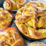 an assortment of vegan paska breads sit on a gingham tablecloth.