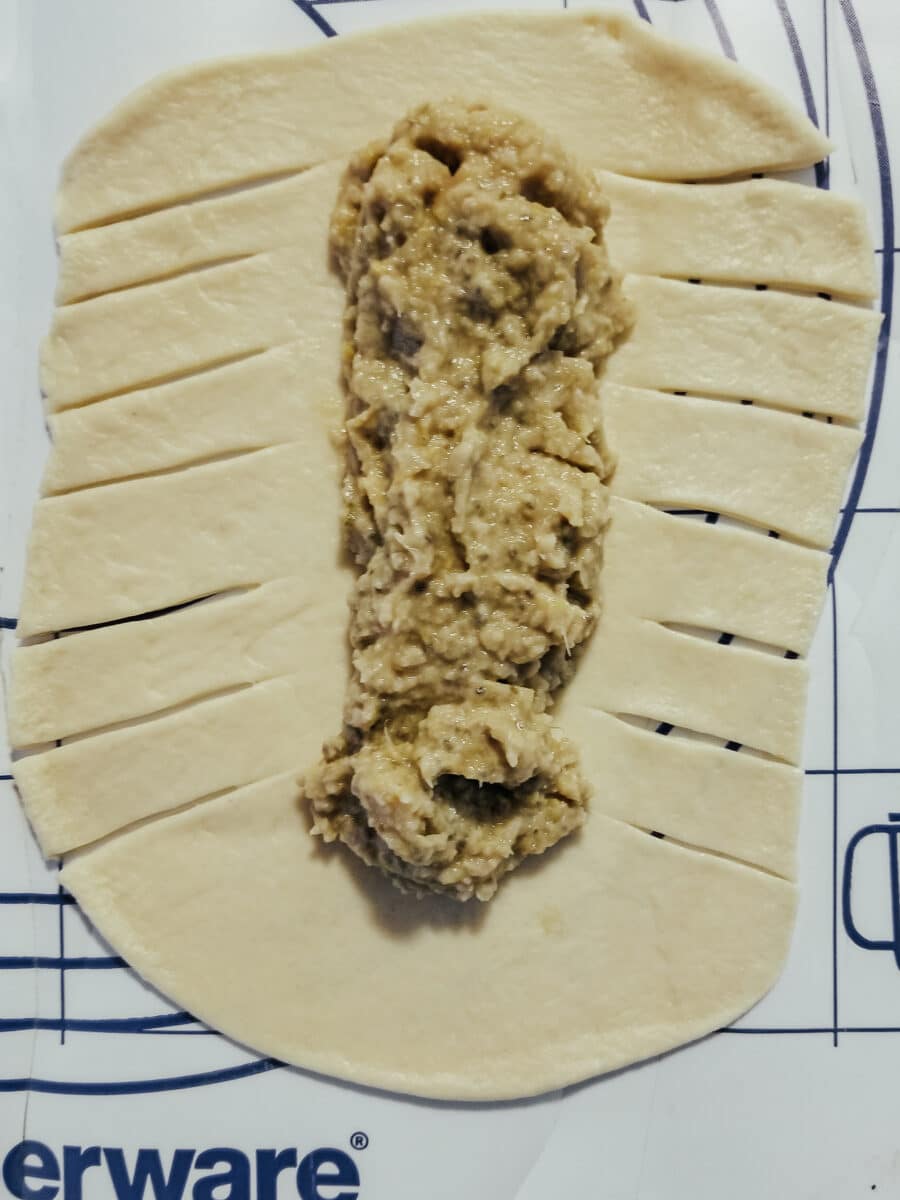 slicing crescent roll dough for goldfish in a blanket