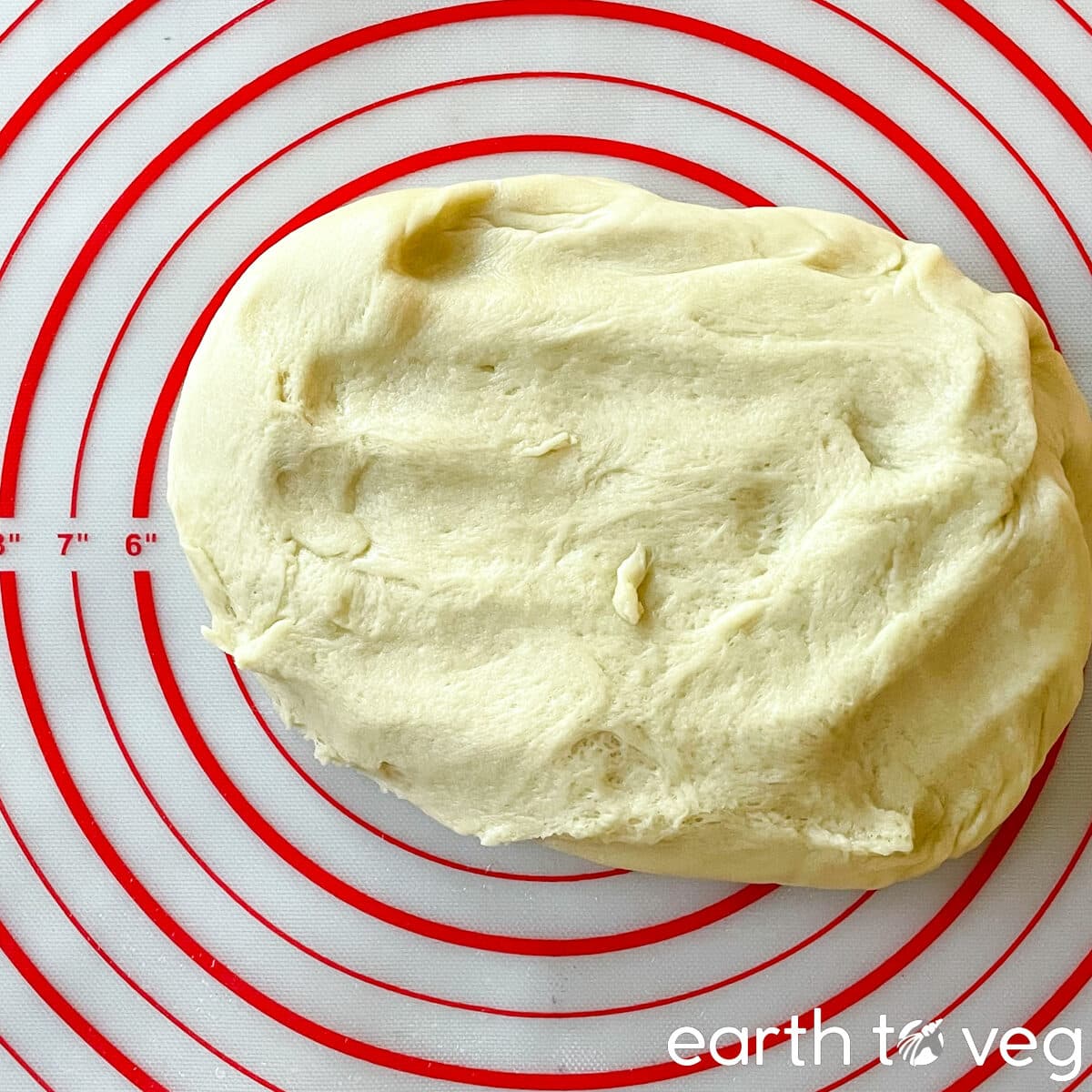 A ball of kneaded pandan dough rests on a silicon mat.