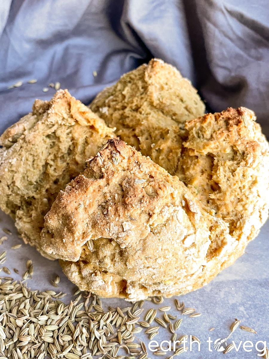 a loaf of whole wheat soda bread on a grey tile backdrop