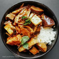 Vegan jungle curry in a black bowl.
