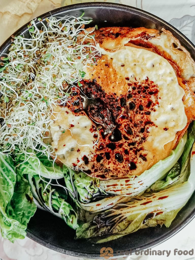 vegan fried eggs and alfalfa sprouts over baby bok choy