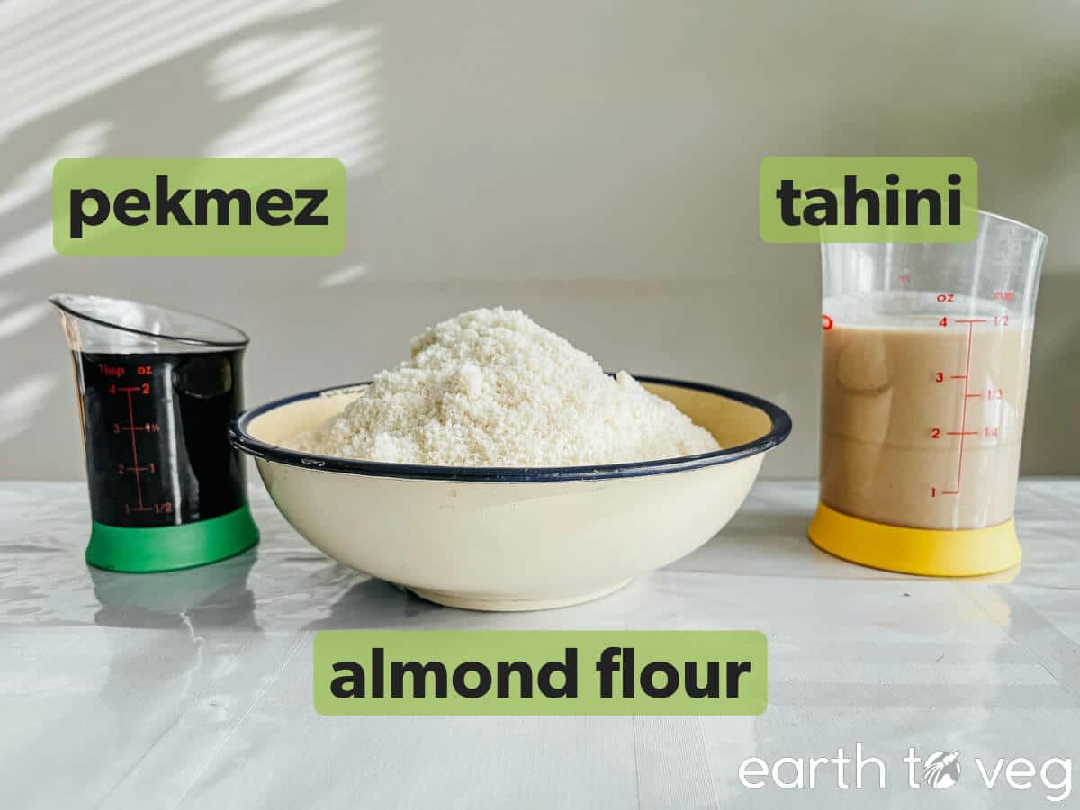 Pekmez, almond flour, and tahini sit on a kitchen table.