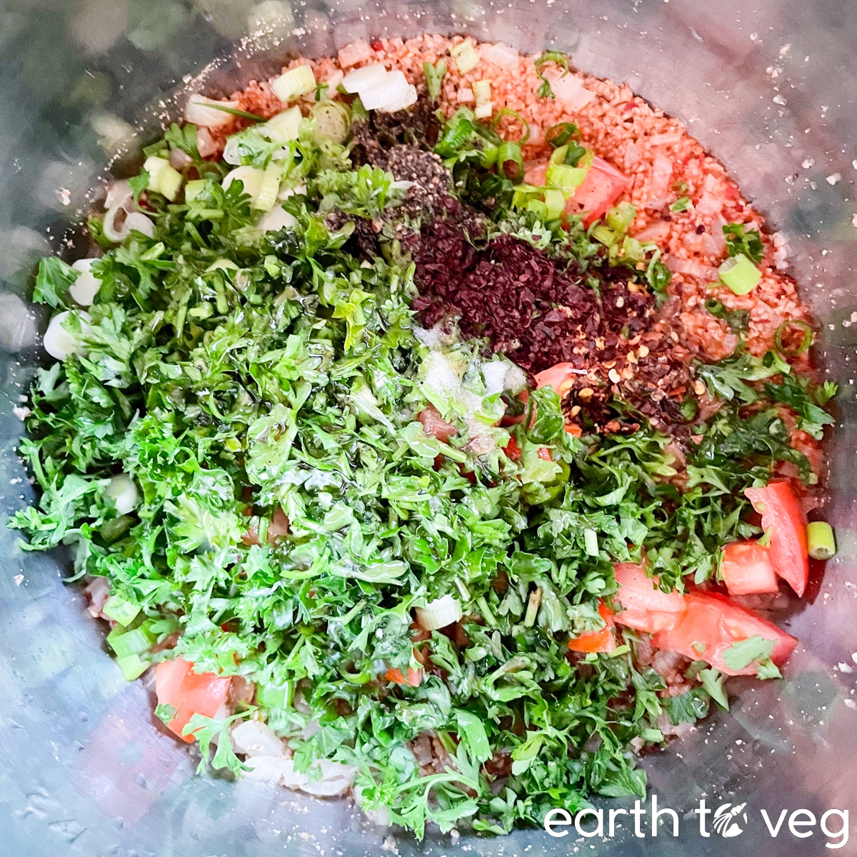 Parsley, green onions, and spices are layered on top of the salad base.