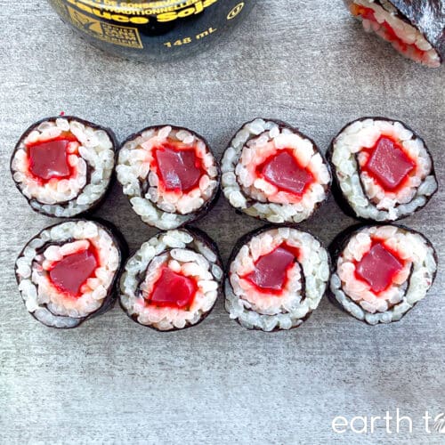 Marinated konjac maki sushi pieces on a grey counter.