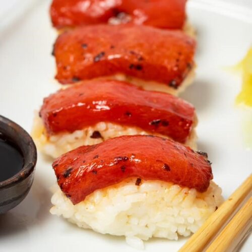 Vegan watermelon tuna nigiri on a white platter.