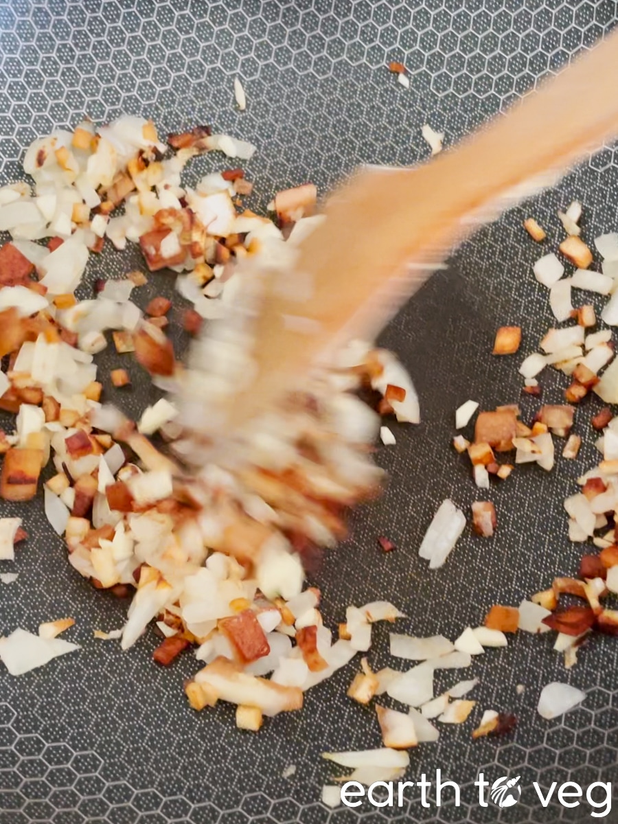 The onions or scallions are added to the hot wok.