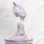 A thick spoonful of taro paste is held up to the camera.