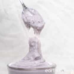 A thick spoonful of taro paste is held up to the camera.
