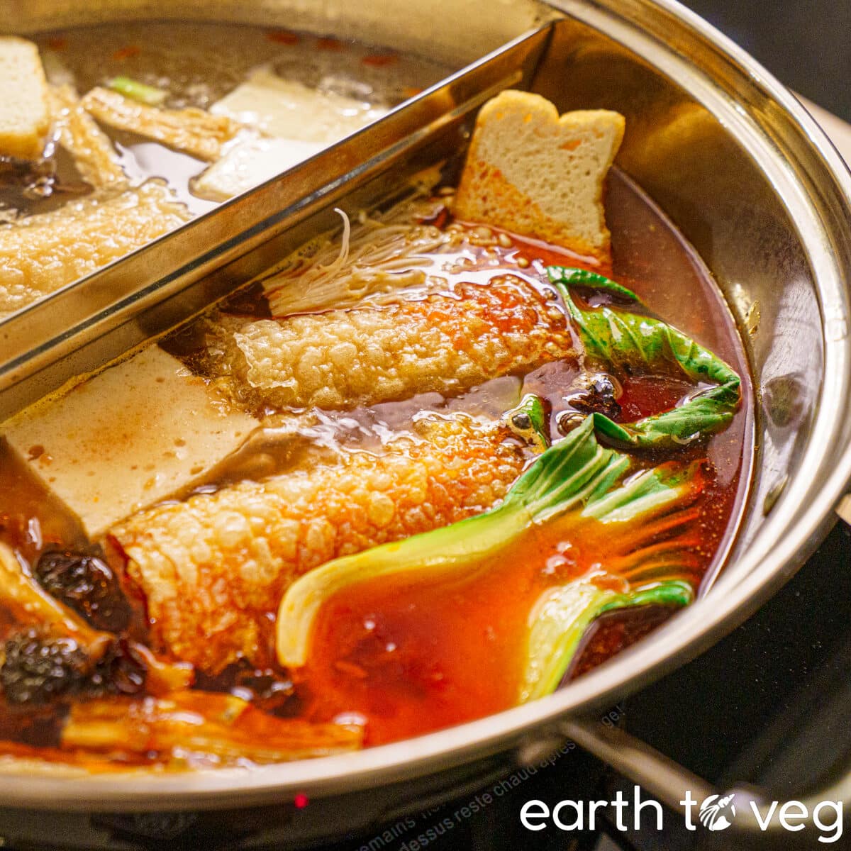 Vegan Chinese hot pot simmering in a spicy mala soup base.