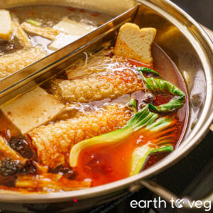 vegan chinese hot pot simmering in a spicy mala soup base