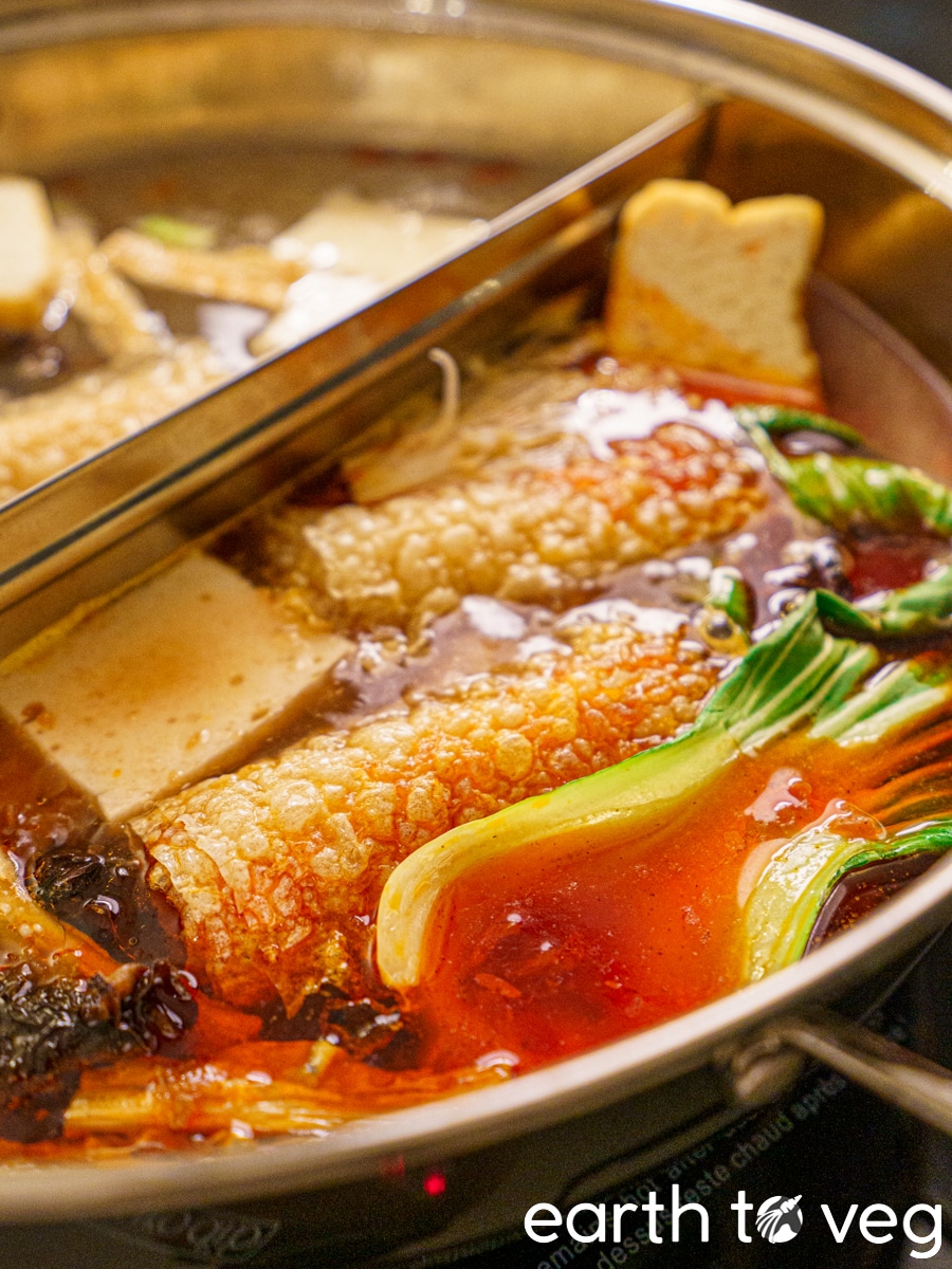 Vegan hot pot ingredients simmer in a spicy broth.