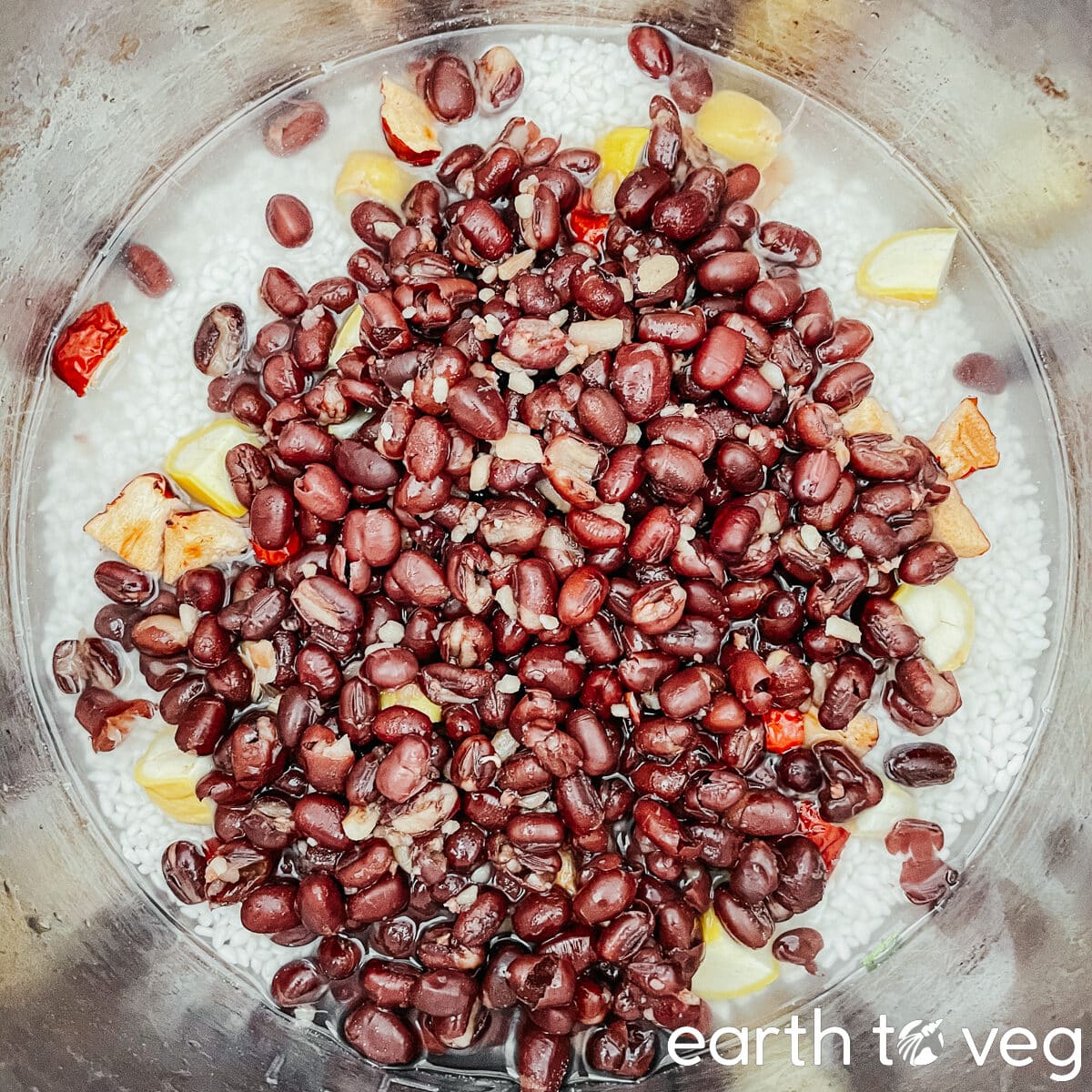 A stainless steel Instant Pot inner pot filled with adzuki beans, sticky rice, chestnuts, jujubes, and water.