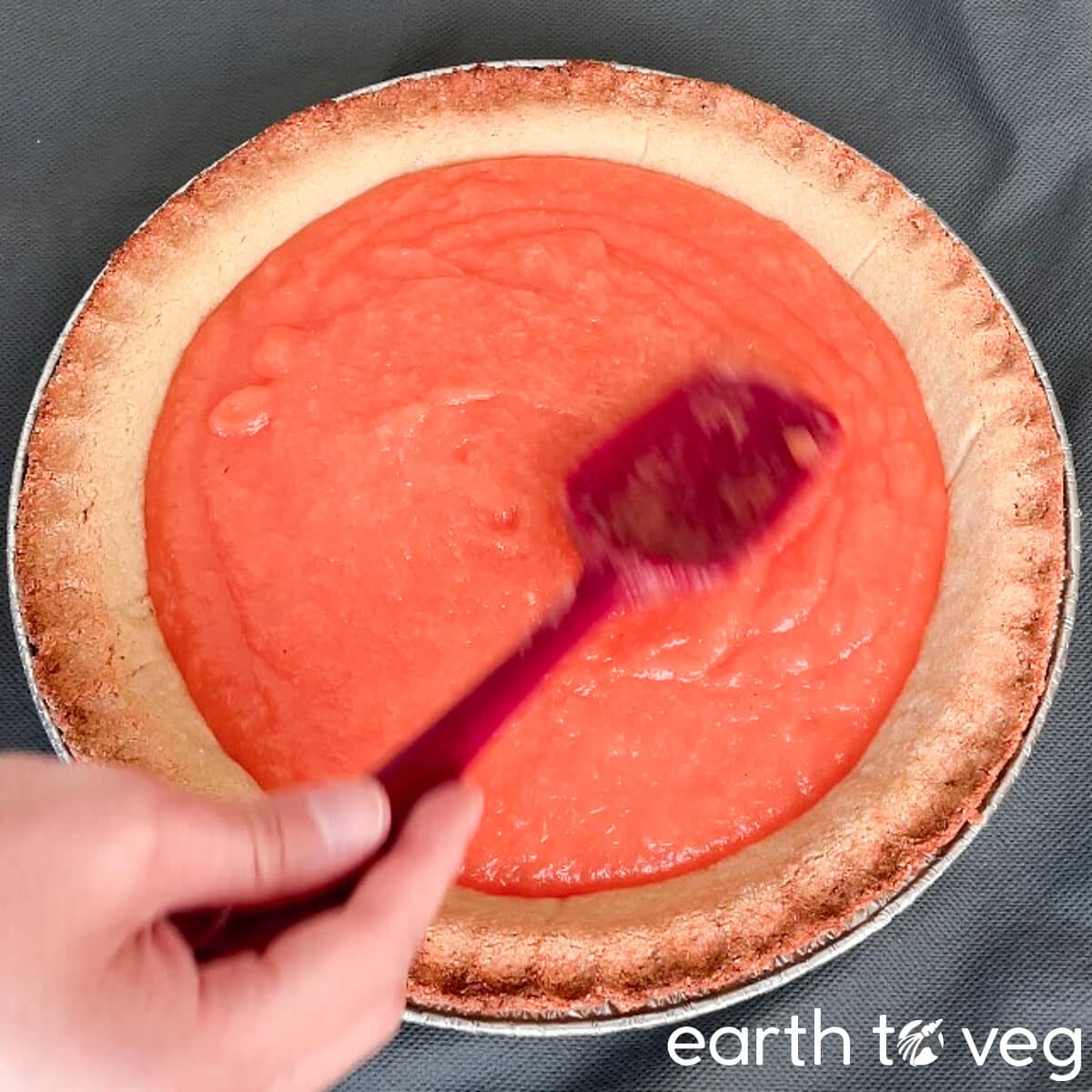 Smoothing pie filling with the back of a spatula.