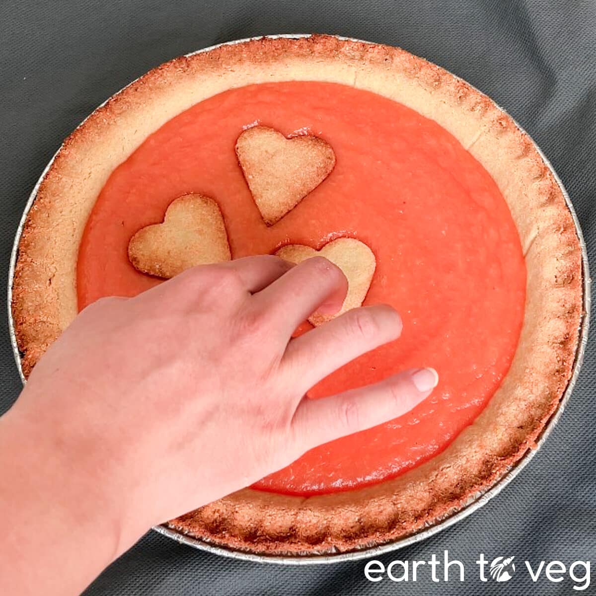 Decorating pink pineapple pie with baked pastry cut-outs.