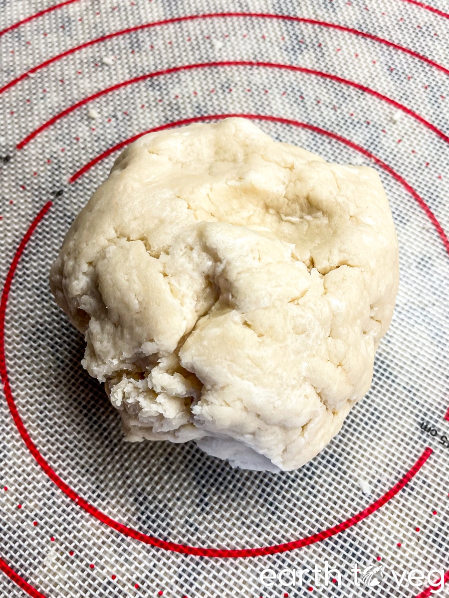 The pie dough is pressed together into a ball.