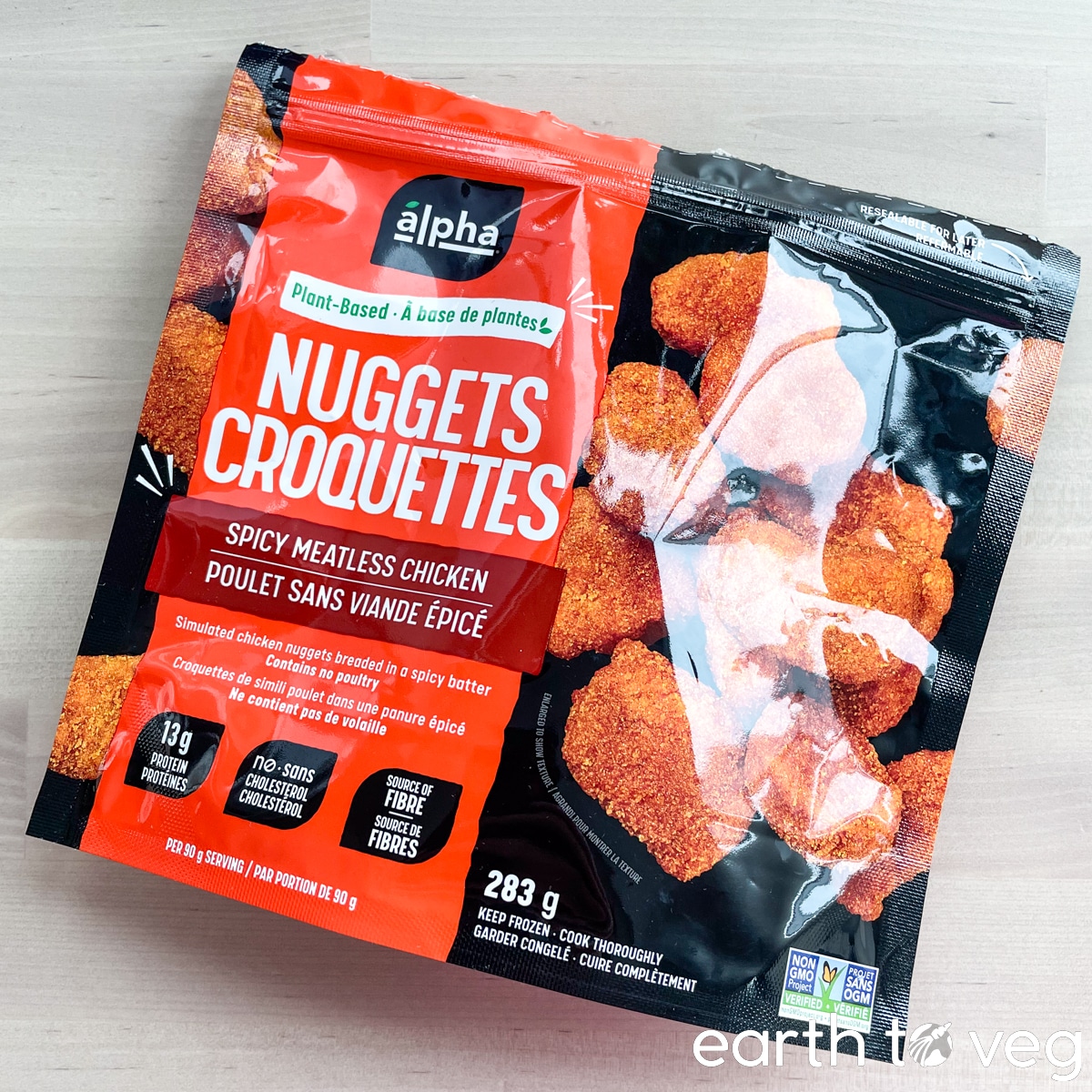 A package of Alpha Foods Sizzlin' Spicy Chik'n Nuggets on a wooden surface.