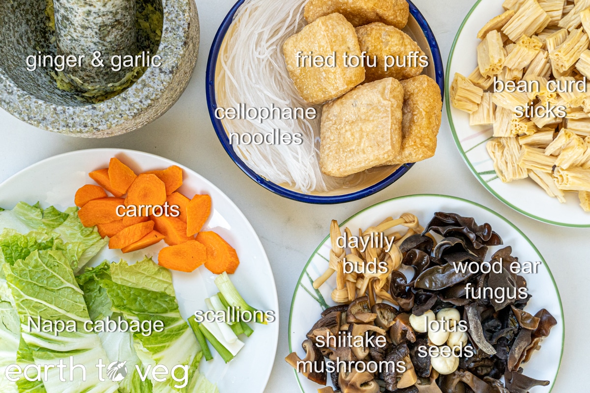 labelled ingredients for buddha's delight: ginger, garlic, cellophane noodles, fried tofu puffs, bean curd sticks, carrots, napa cabbage, daylily buds, lotus seeds, shiitake mushrooms, wood ear fungus, scallions