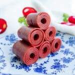 stack of six rolls of chinese haw leather on a blue white patterned china plate