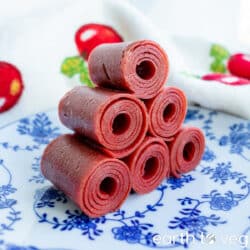 stack of six rolls of chinese haw leather on a blue white patterned china plate