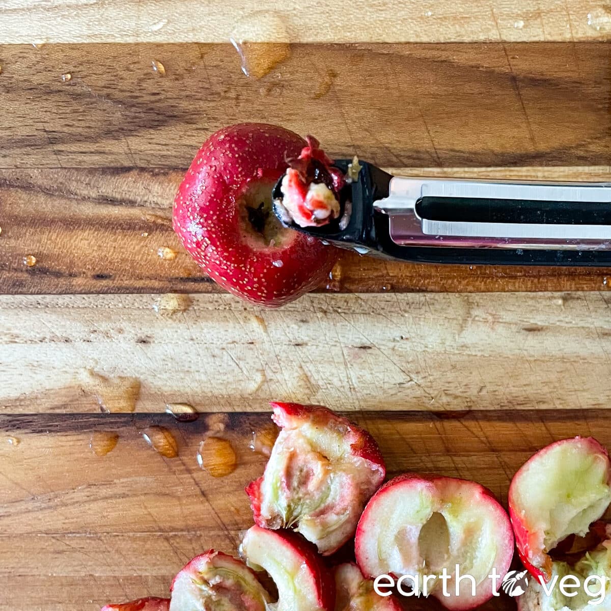 A swivel peeler with potato eye remover next to a hawthorn berry.