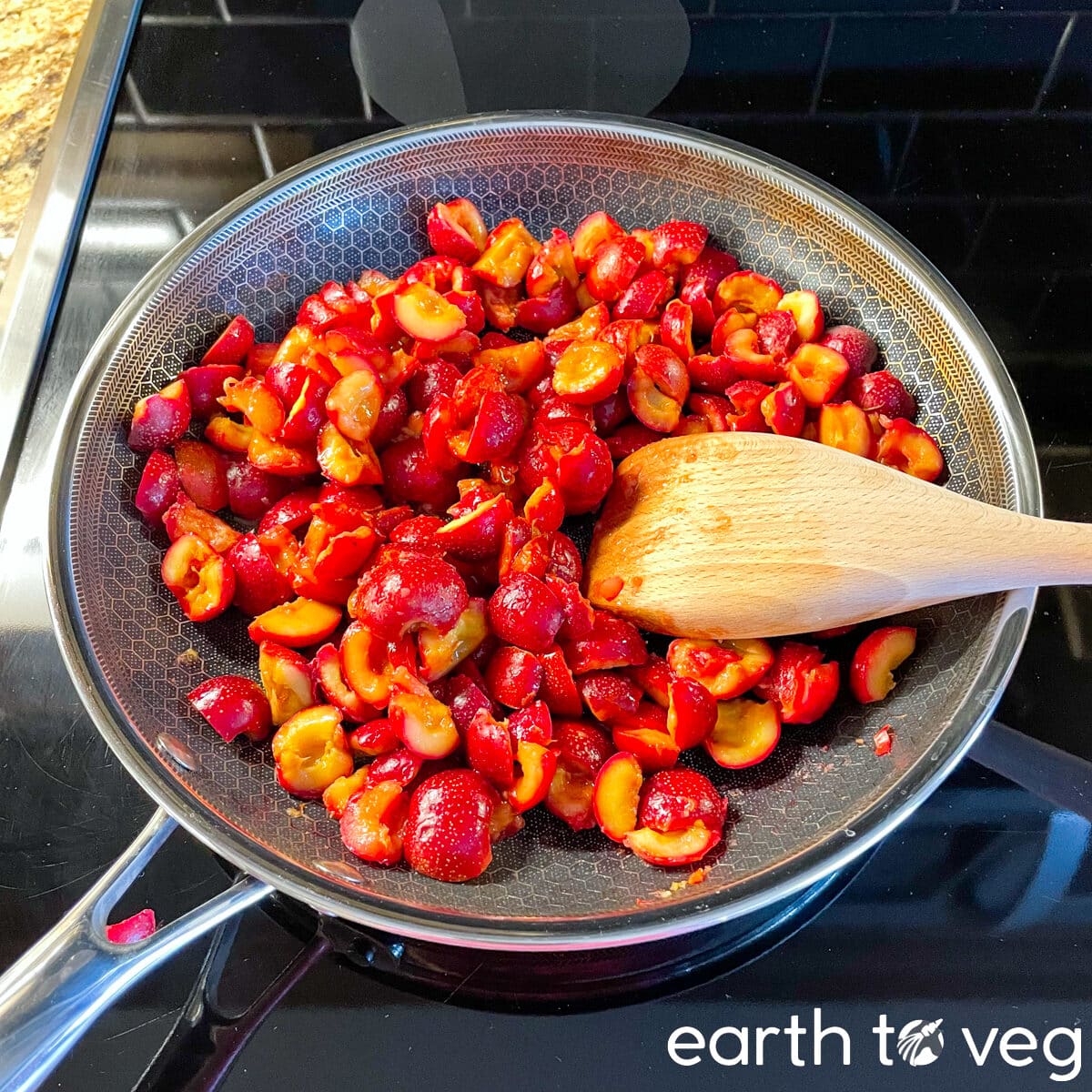 wooden spatula resting in a hexclad nonstick saucepan filled with cooked Chinese hawthorn berries