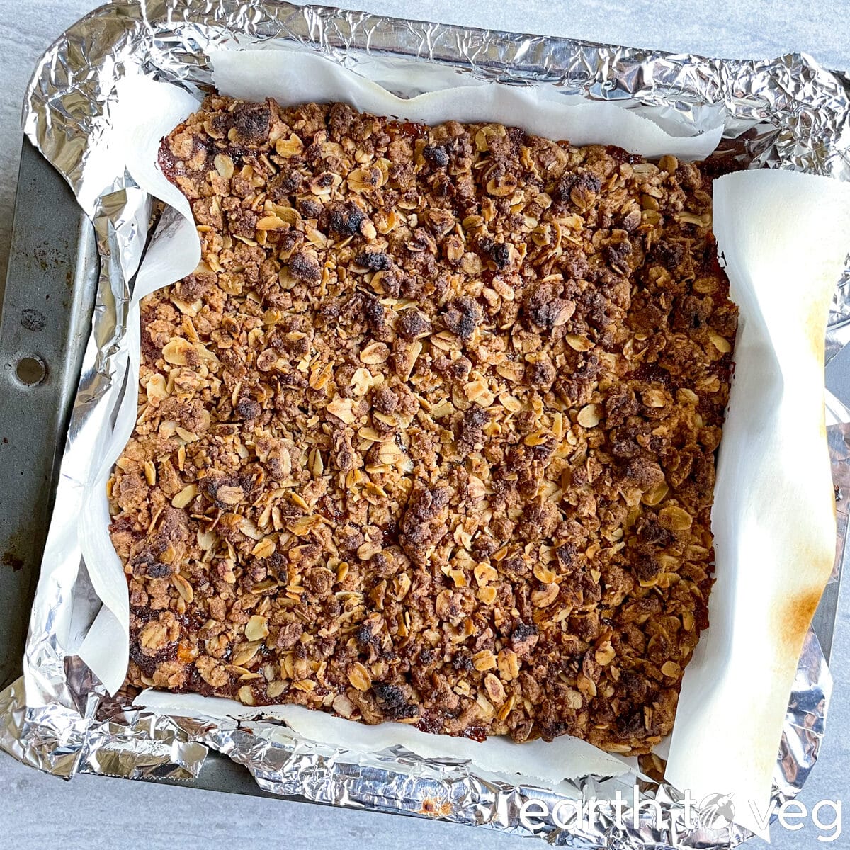 Freshly baked Icelandic hjónabandssæla in a lined metal baking pan.