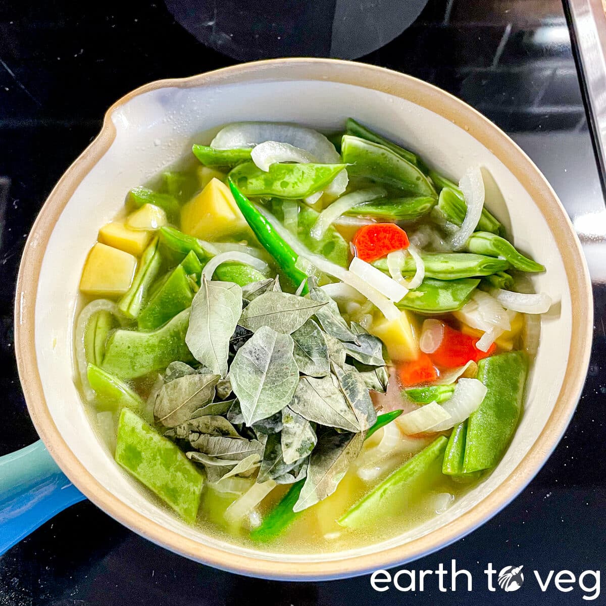curry leaves laid on top of vegetables for ishtew