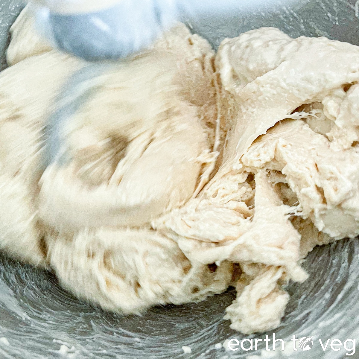 Pandan-flavoured bread dough is kneaded by a dough hook in a stand mixer.