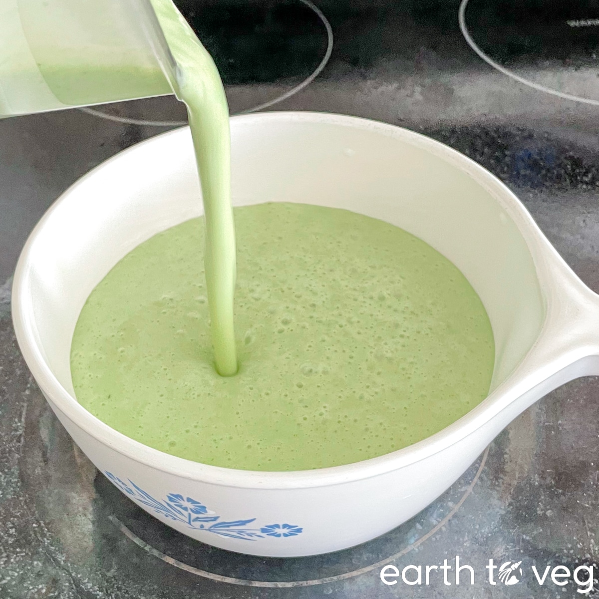 Uncooked pandan kaya mixture is being poured into a small saucepan.