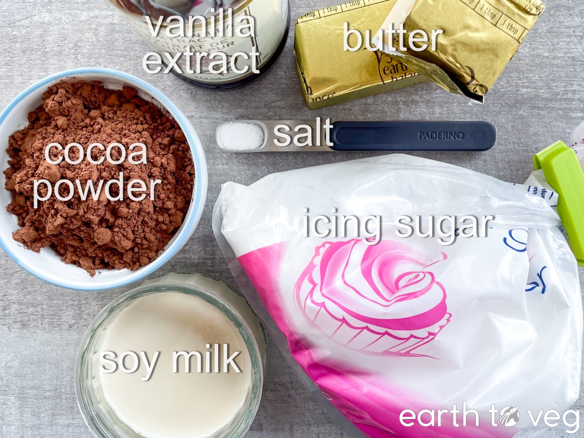 Ingredients for chocolate blender frosting are laid out on a grey countertop.
