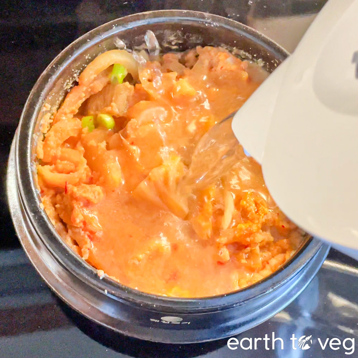 Additional water is poured into the cooked kongbiji jjigae.