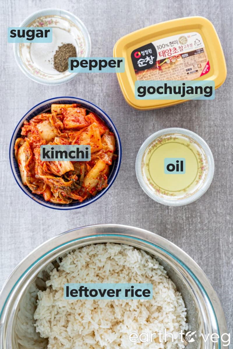 Ingredients for kimchi fried rice are arranged on a grey countertop.