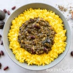 A large bowl of yellow basmati rice with ghormeh sabzi in the centre.