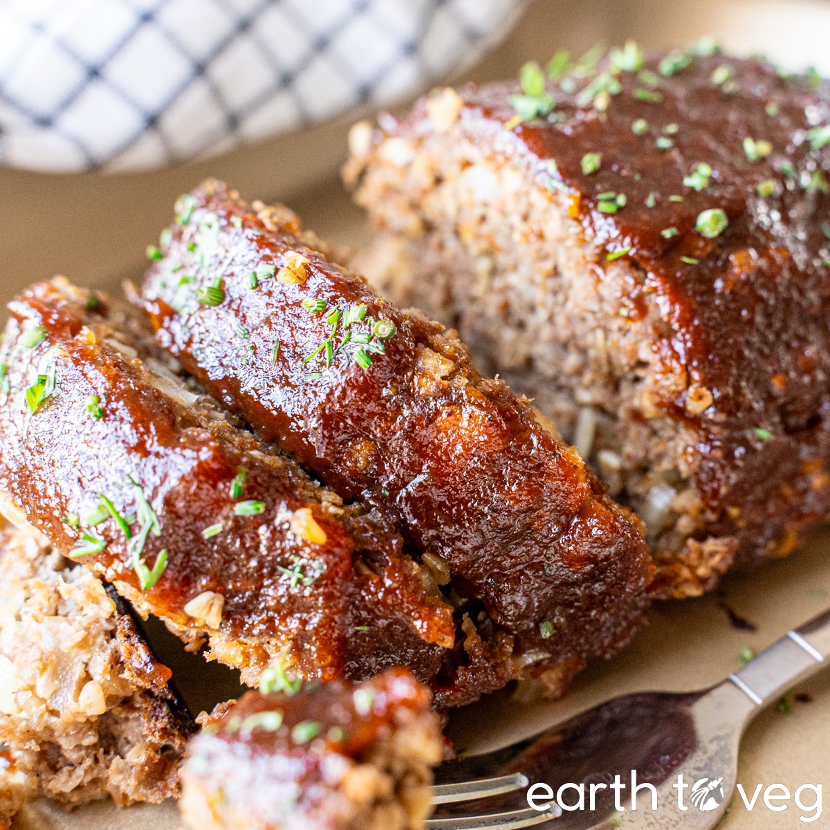 Impossible Meatloaf slices on a golden baking pan.