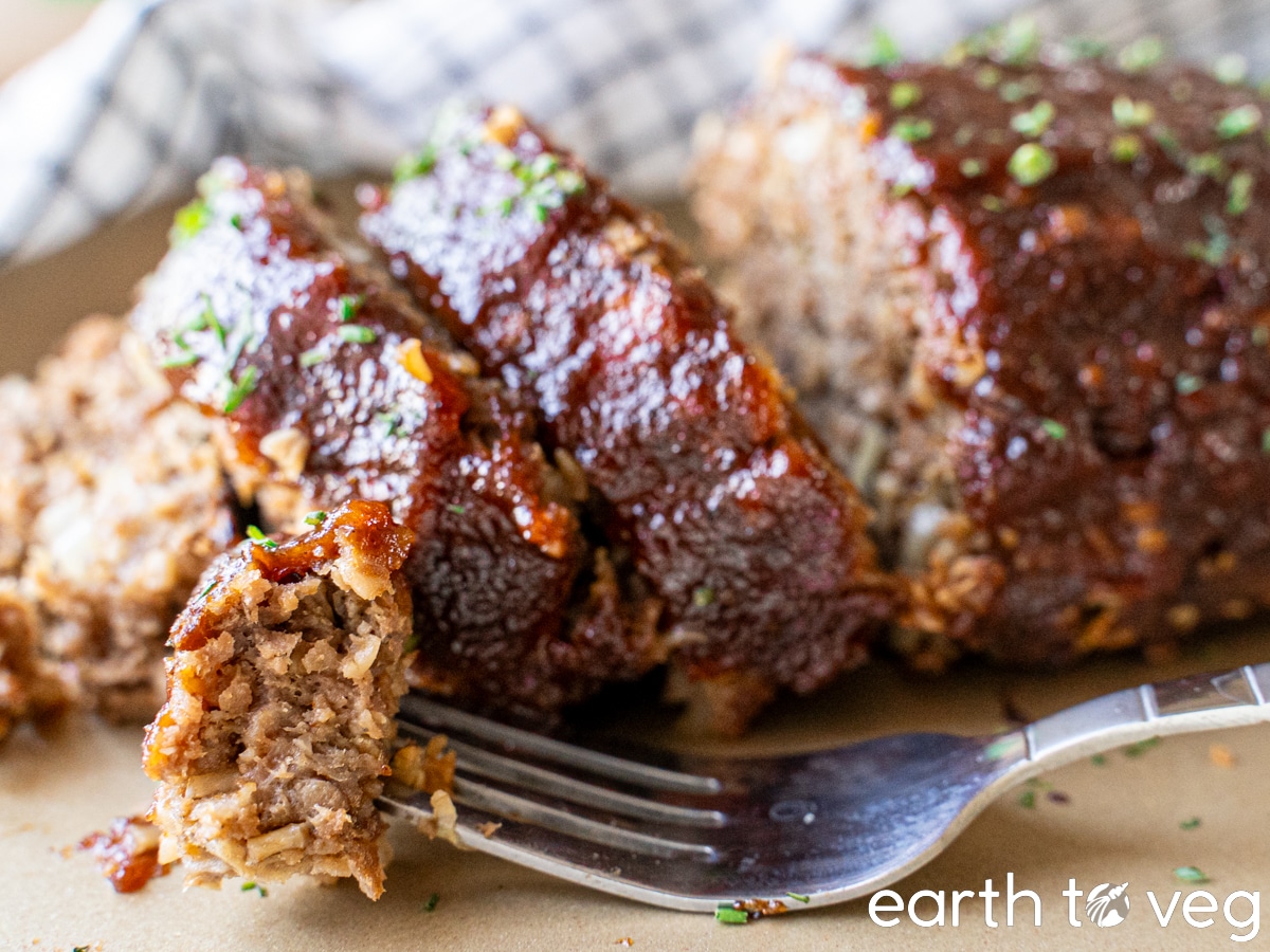 A fork lies on a tray with a sliced Impossible Meatloaf in the background.