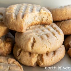 Stack of vegan peanut butter cookies on a metallic golden baking tray.