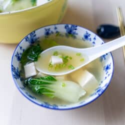 A small blue china bowl of bok choy miso soup.