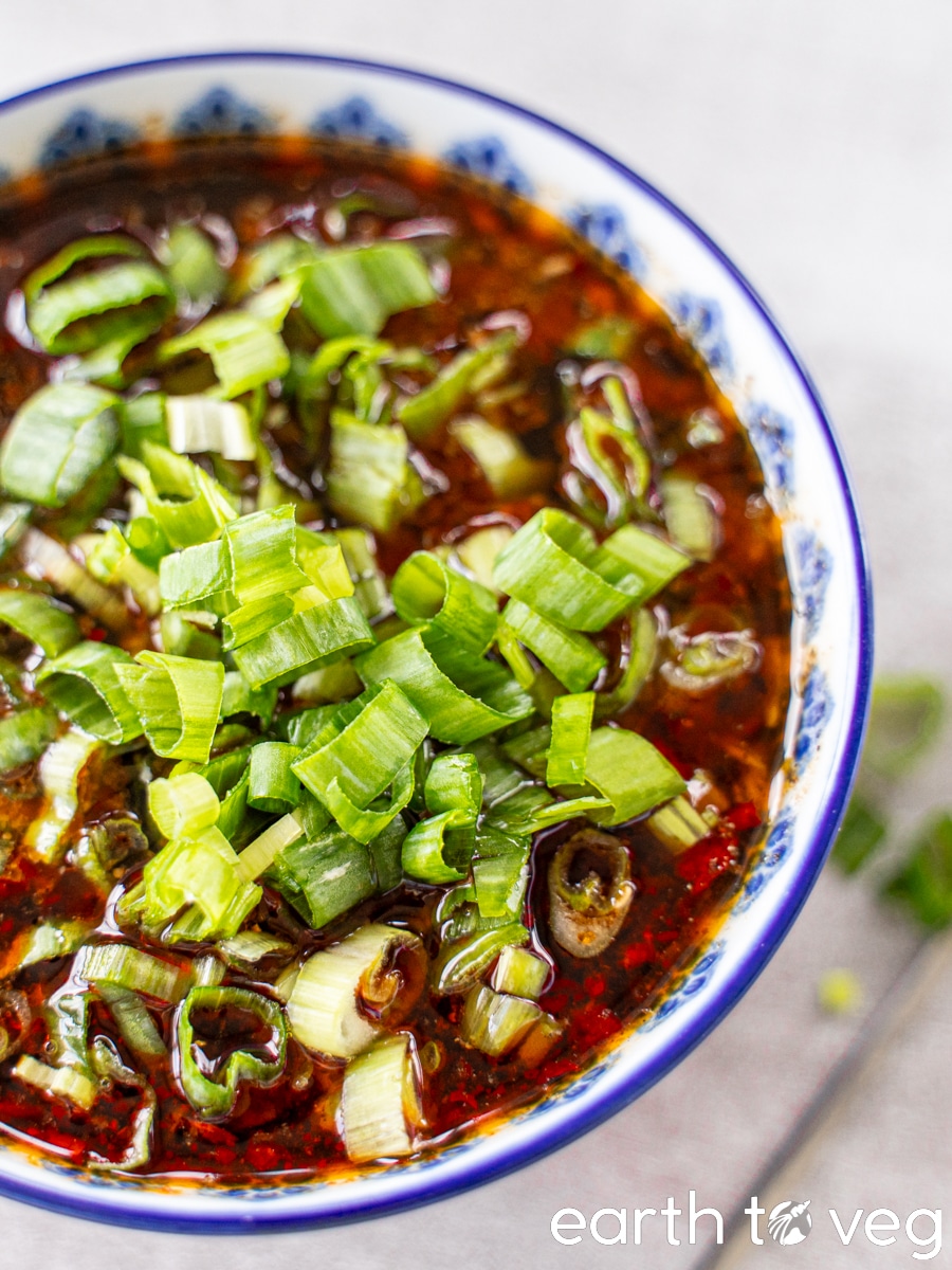 A blue and white bowl full of Chinese hot pot dip.