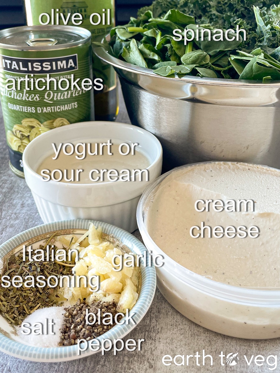 Ingredients for vegan spinach artichoke dip assembled on a grey countertop.