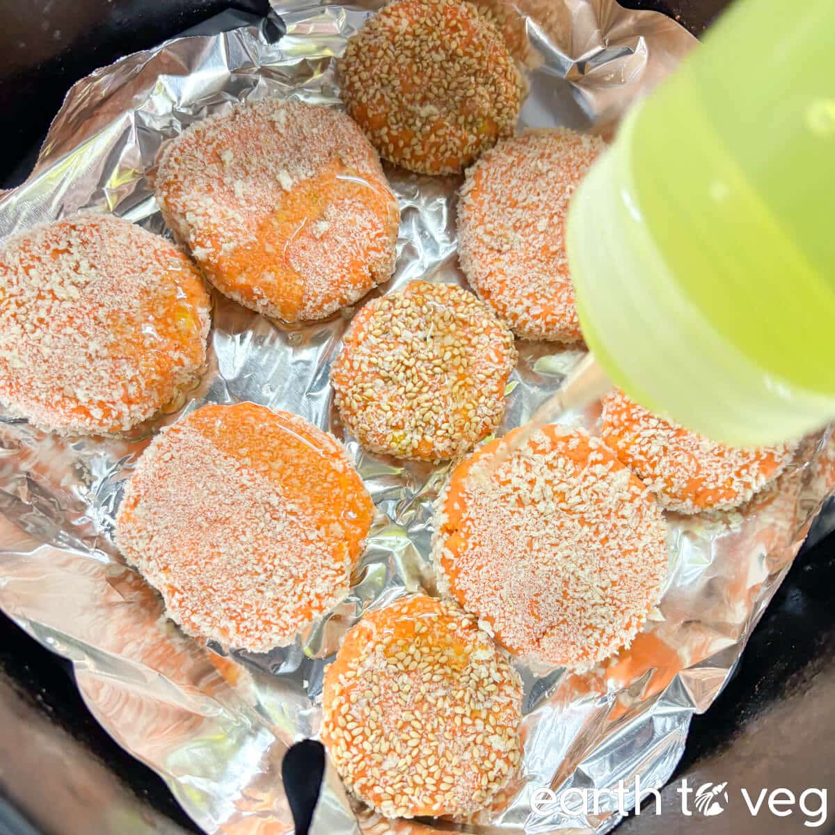 The pumpkin rice cakes are put into an air fryer and drizzled with oil.