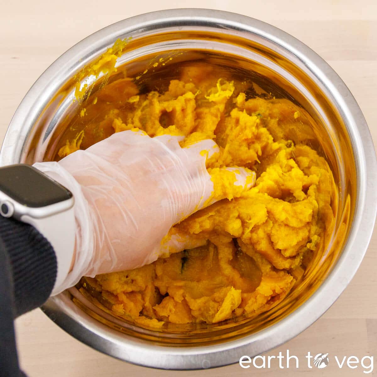 Pumpkin puree is mashed by hand until smooth.