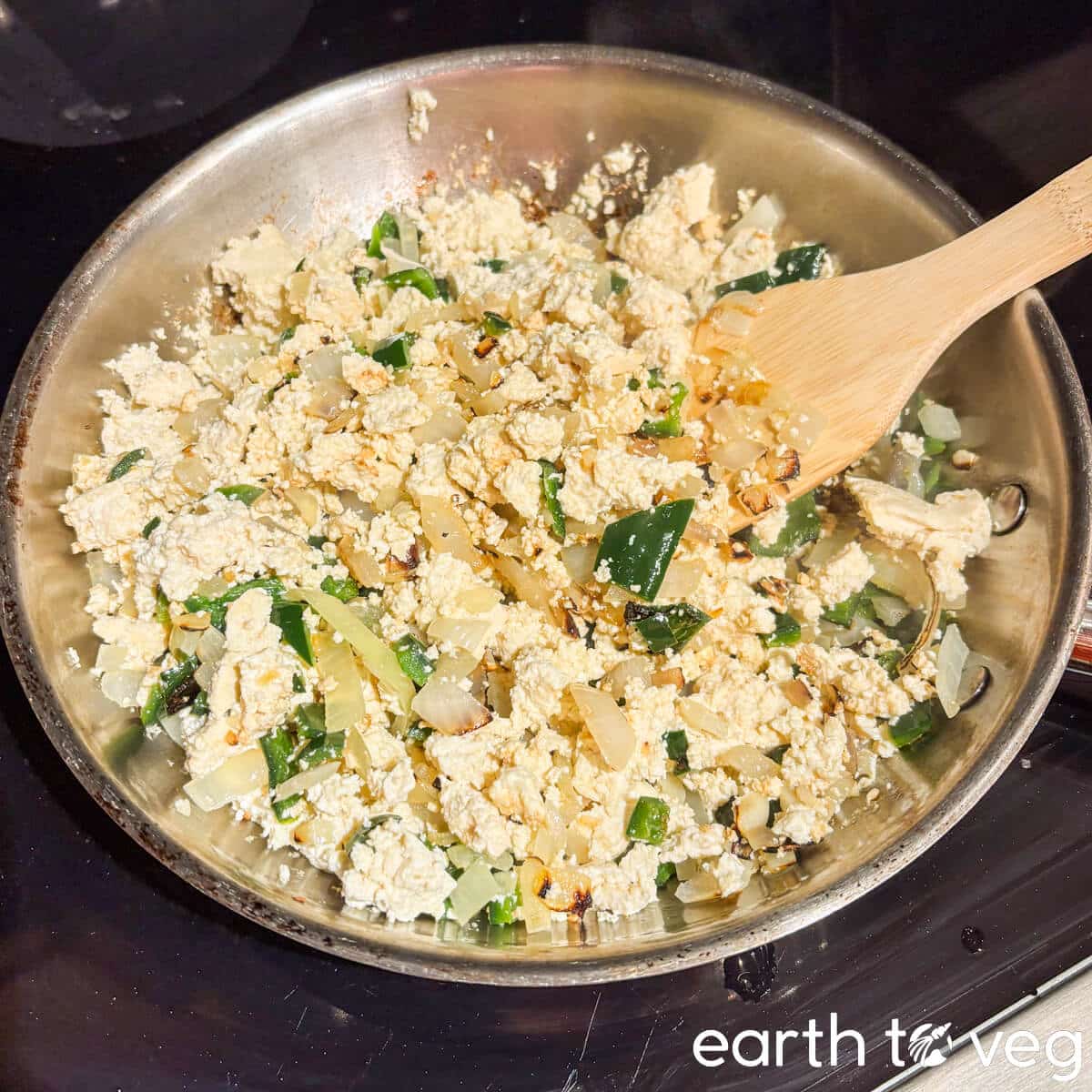 Crumbled tofu is sauteed in the pan with onions and garlic.