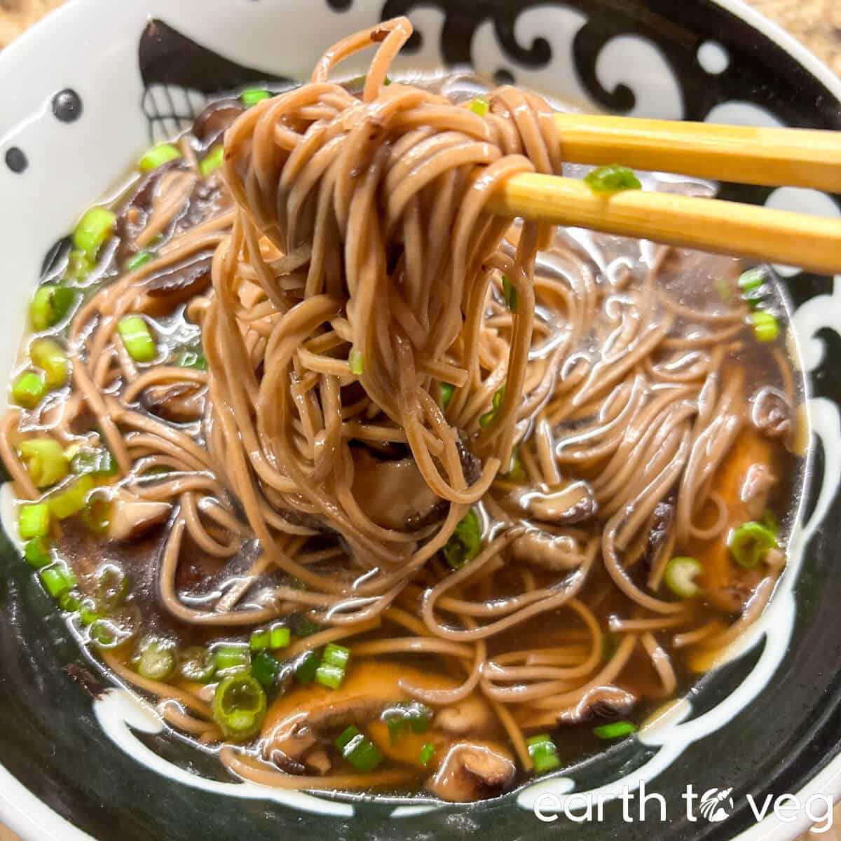 Eating shiitake soba noodles with chopsticks.