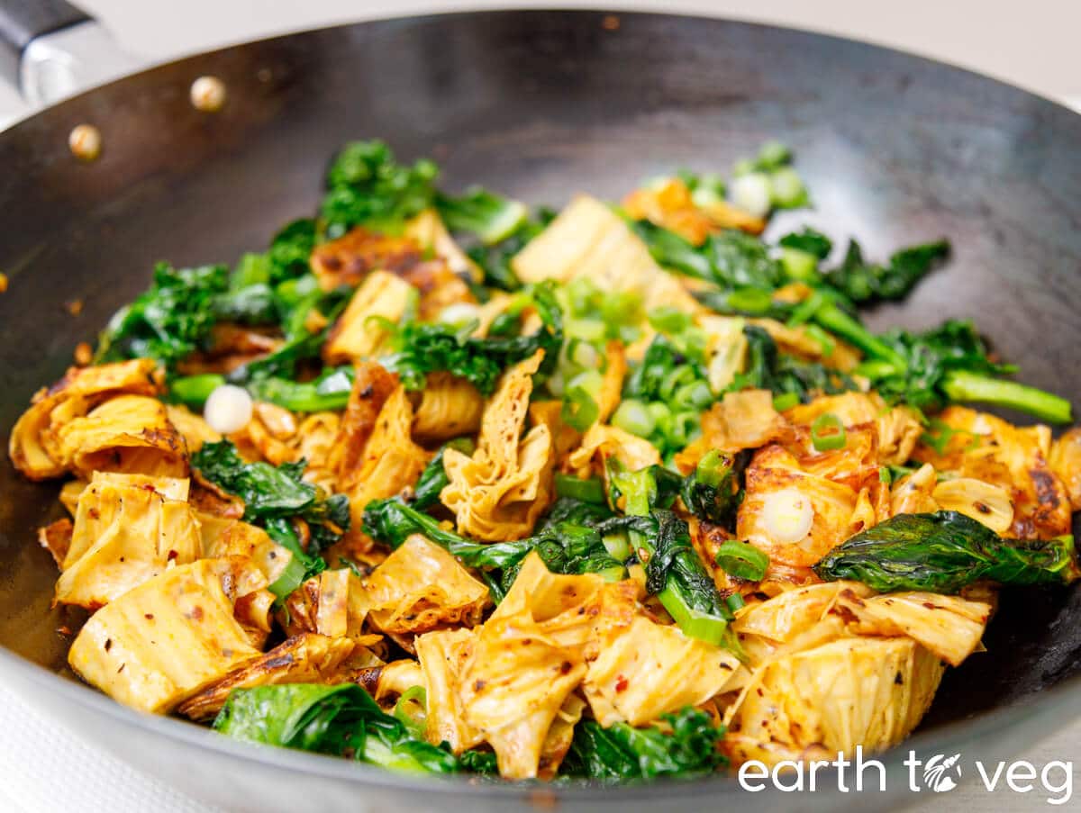 Stir fried tofu skin in a carbon steel wok.