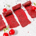 Sour cherry lavashak rolls on a white countertop.