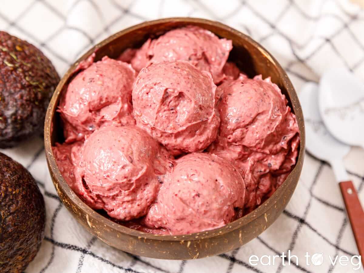 A bowl of strawberry avocado ice cream scoops.